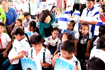 : Bà Bùi Thị Hương, Giám Đốc Điều Hành Vinamilk trao tặng sữa cho các em học sinh Vĩnh Long.